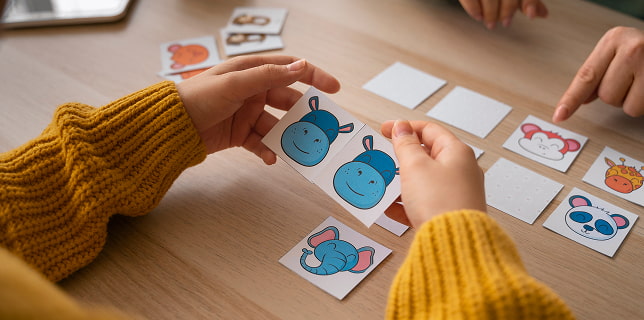 Babysitting Niño jugando a un juego de memoria con tarjetas ilustradas