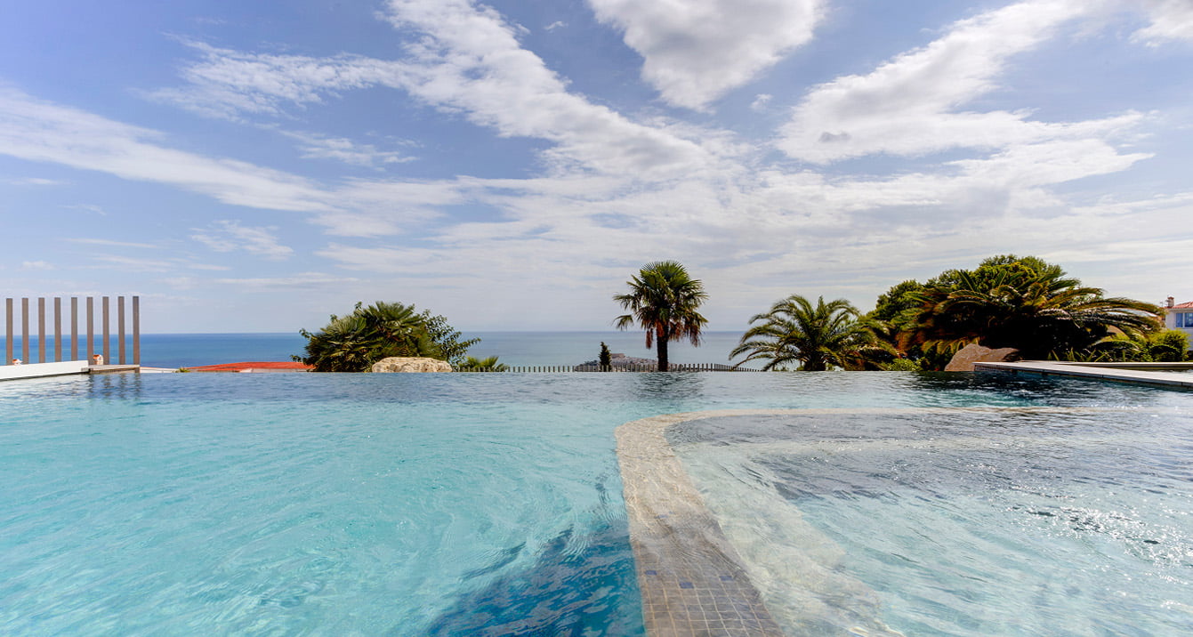 Piscina infinita y jacuzzi Piscina infinita con jacuzzi y vistas al mar