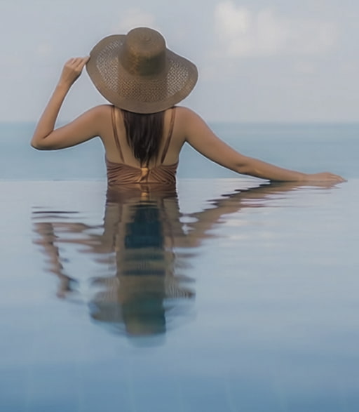 Villa Delta infinity pool Woman relaxing by the pool with sea views