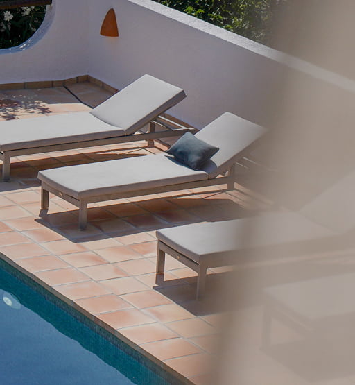 Tumbonas en una soleada terraza junto a la piscina.
