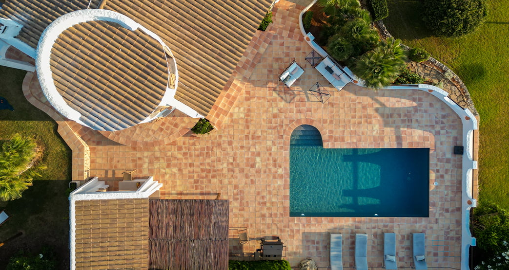 Vista aérea de una terraza con piscina y tumbonas.