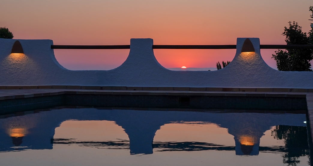 Puesta de sol vista desde la terraza con piscina.