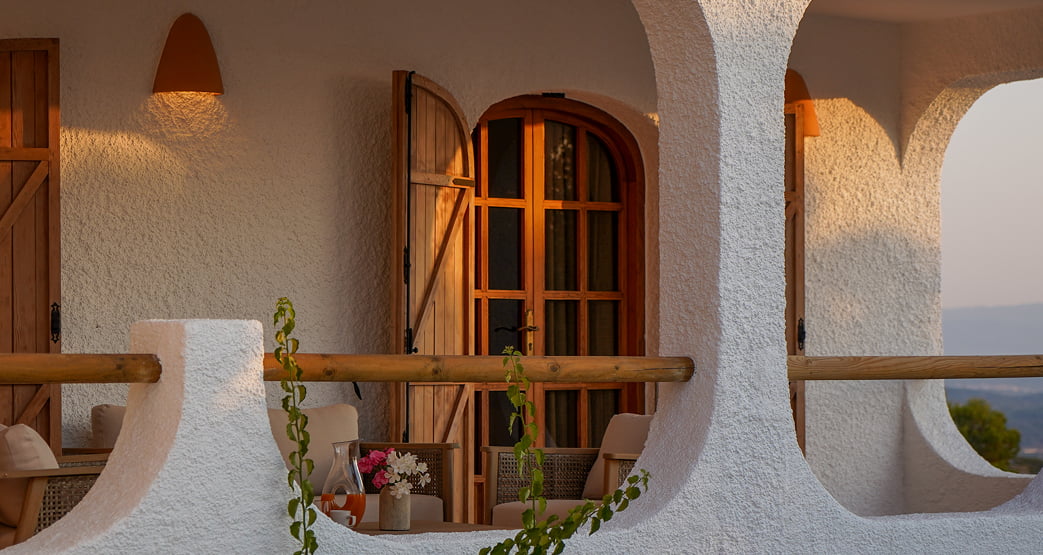 Terraza exterior con arcos blancos y luz de atardecer.